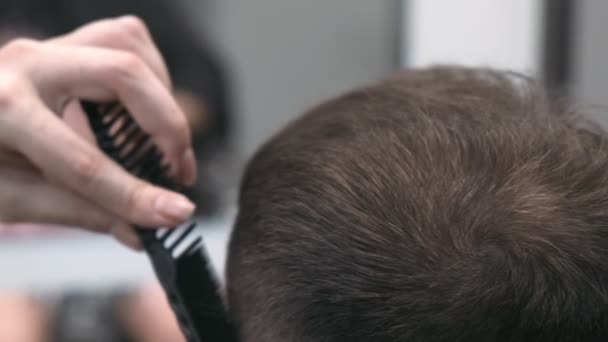 Peluquero femenino profesional peinando y cortando el pelo del hombre. Primer plano, cámara lenta
 - Metraje, vídeo