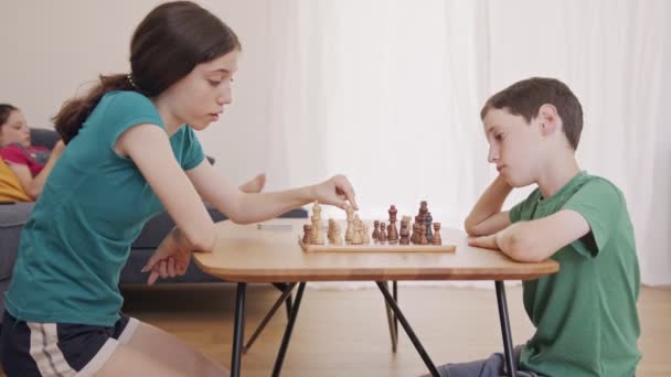 Young kids playing Chess on the living room table - Metraje, vídeo