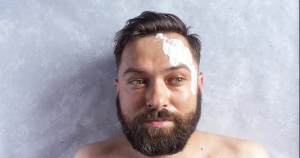 Brunette man met een baard in een spa salon krijgt klei masker met komkommers op de ogen. Grappig Stop beweging animatie - Video