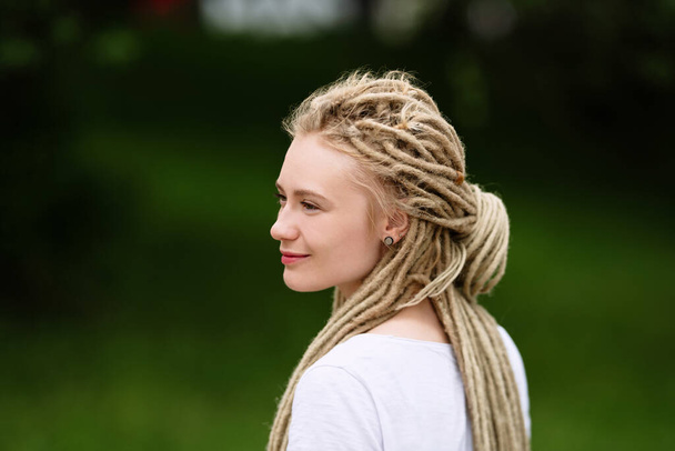 profile girl with an unusual hairstyle, white dreadlocks, close-up - Фото, изображение