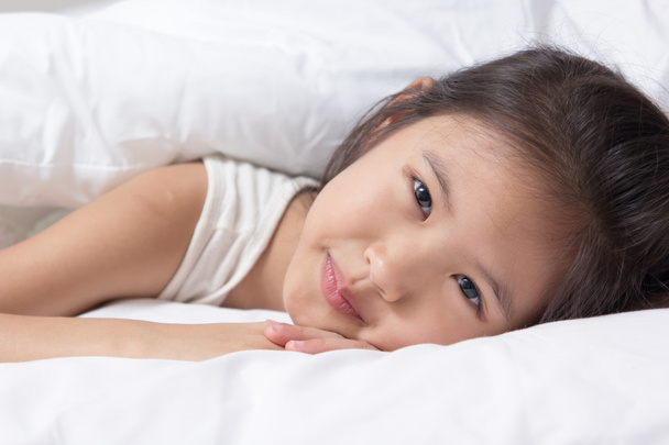 aranyos ázsiai kislány awaked fel az ágyában - Fotó, kép