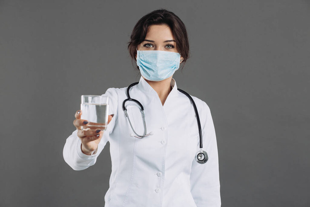 El médico sostiene un vaso de agua y recomienda beber agua para combatir el coronavirus 2019-ncov
 - Foto, Imagen