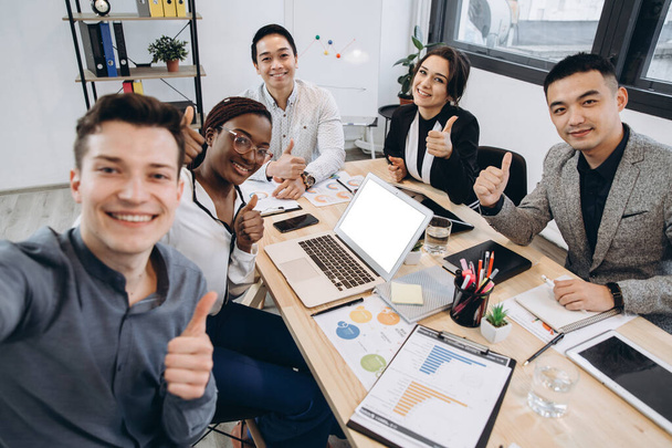 Multicultural group of professional business people making selfie in modern office - Фото, зображення