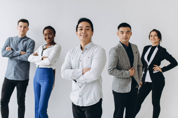 Cheerful multiracial professional business people laughing together standing in row near wall, happy diverse young employees students group, corporate staff team having fun, human resource concept - Photo, Image