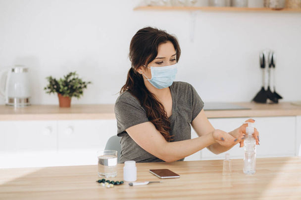 COVID-19 Young woman using wash hand sanitizer gel dispenser, against Novel coronavirus (2019-nCoV) at home. Home isolation, Auto Quarantine, Antiseptic, Hygiene and Healthcare concept. - Foto, Imagem