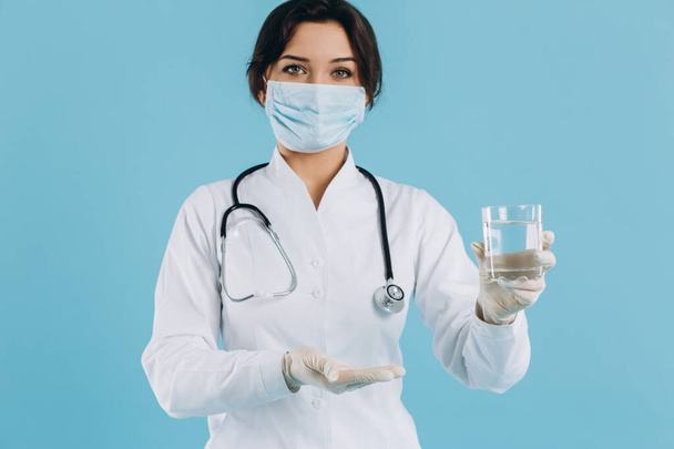 Kadın doktor elinde bir bardak su tutuyor ve Coronavirus 2019-ncov ile savaşmak için içme suyu öneriyor. - Fotoğraf, Görsel