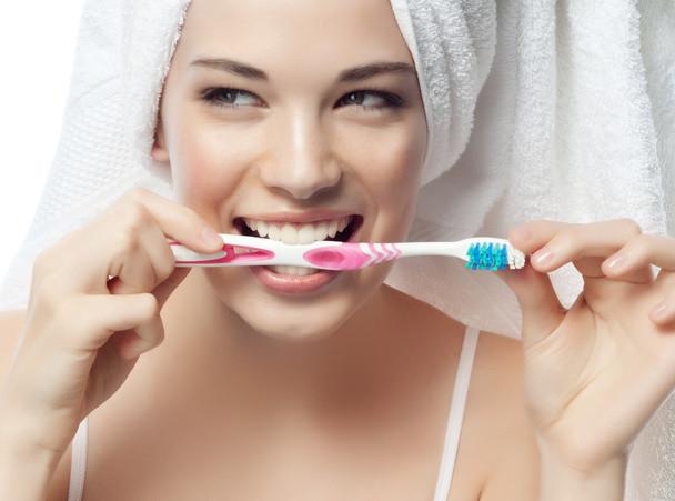 Smiling woman is brushing her teeth - 写真・画像