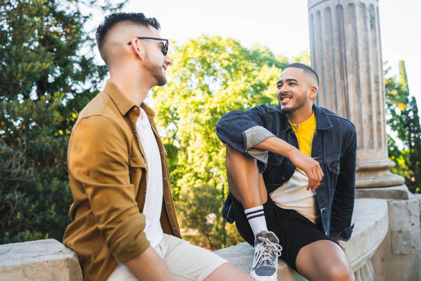Portrait of happy gay couple spending time together and having a date at the park. Lgbt and love concept. - 写真・画像