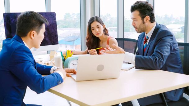 Smart businessman and businesswoman talking discussion in group meeting at office table in a modern office interior. Business collaboration strategic planning and brainstorming of coworkers. - Photo, Image