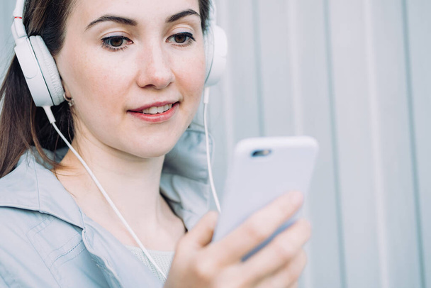 Caucasian girl in headphones listens to an audio message. - Fotó, kép