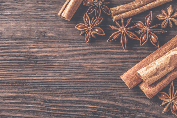 Anise star and  cinnamon sticks on wooden  background. Toned photo. Top view - Foto, imagen