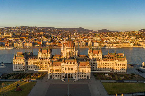 Vuelo aéreo con aviones teledirigidos de la fachada oriental de la plaza Kossuth del Parlamento húngaro durante el amanecer de Budapest en invierno. - Foto, imagen