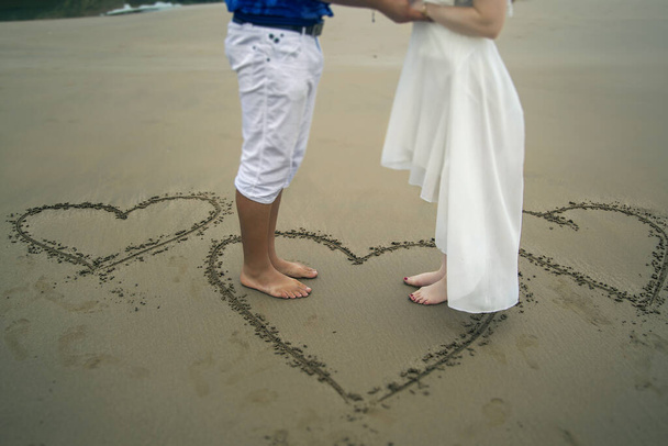 recién casados en la playa en un corazón pintado
 - Foto, imagen