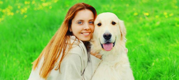 Close up portrait happy owner woman with Golden Retriever dog on green grass - Zdjęcie, obraz