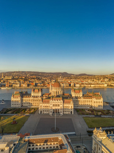Vuelo aéreo con aviones teledirigidos de la fachada oriental de la plaza Kossuth del Parlamento húngaro durante el amanecer de Budapest en invierno. - Foto, imagen