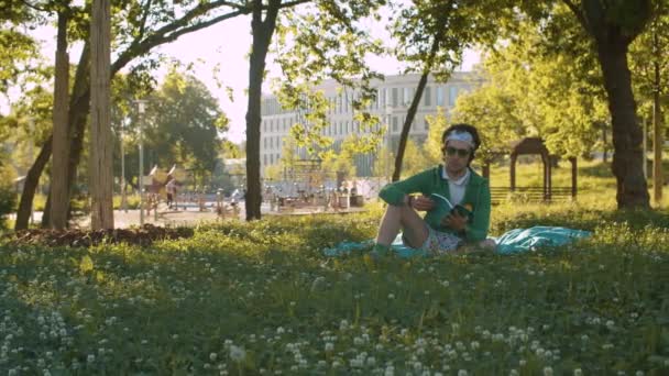 Funny freak man reading a book in the park - Záběry, video