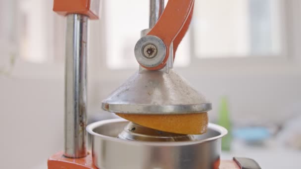 Σούπερ αργή κίνηση του φρέσκου χυμού πορτοκαλιού συμπιέζεται με ένα χειροκίνητο συμπιεστή - Πλάνα, βίντεο