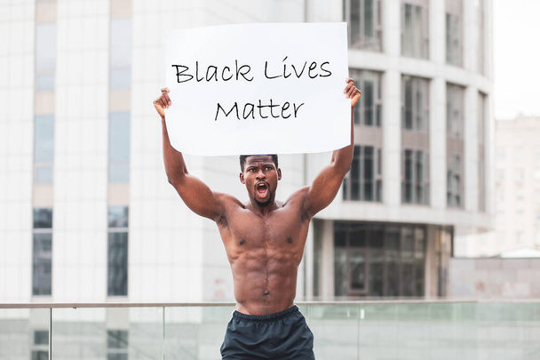 black lives matter concept. aggressive African American with a poster protests and shouts, Americans patriot activist rebellion, copy space - Photo, Image