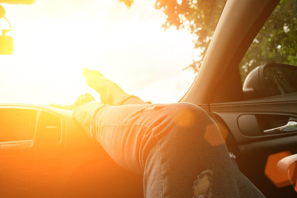 Travel car trip on road at sunset. Happy young woman have fun driving inside vehicle in summer sunny day. Driver ride vacation concept. - Photo, Image
