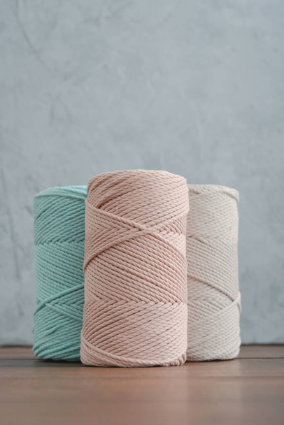 Macrame cotton cord spools in different pastel colors on grey concrete background, top view - Photo, Image