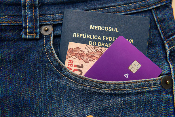 Lähikuva Brasilian passi, setelit ja luottokortti housuissa taskussa. Käännä: Mercosur - Brasilian liittotasavalta - Passi. - Valokuva, kuva