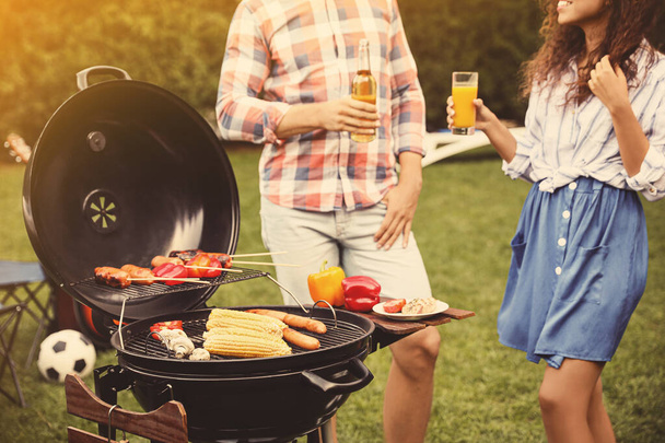 People with beverages near barbecue grill outdoors on sunny day - Foto, Imagem