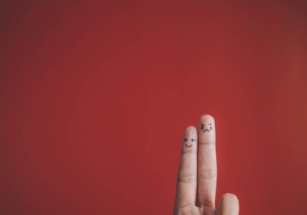 Δάχτυλο με συναίσθημα στο κόκκινο φόντο - Φωτογραφία, εικόνα