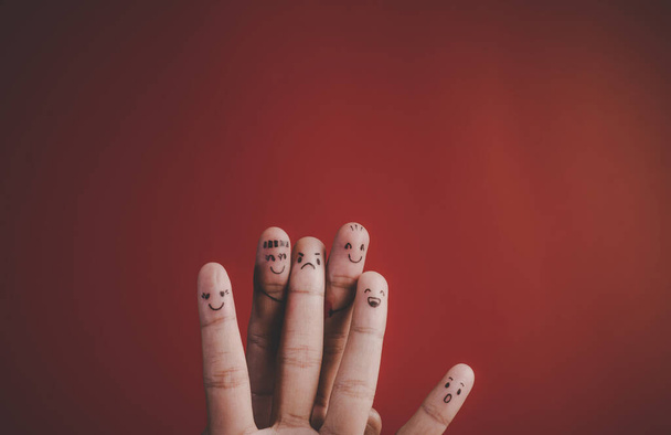 Finger mit Emotionen auf rotem Hintergrund - Foto, Bild