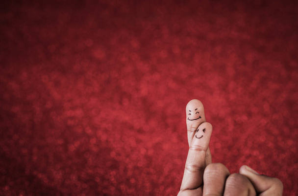 Finger with emotion on red background - Foto, afbeelding