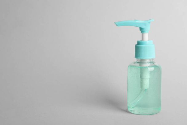Dispenser bottle with antiseptic gel on light grey background. Space for text - Фото, зображення