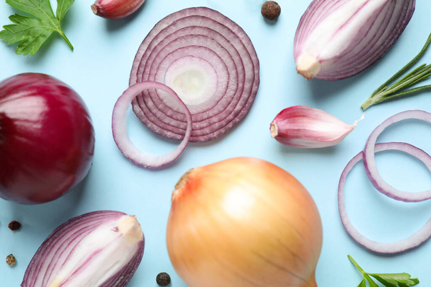 Flat lay composition with onion and spices on light blue background - 写真・画像