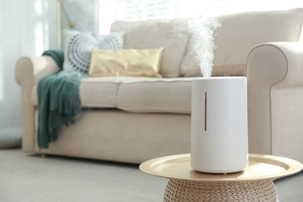 Modern air humidifier on table in living room. Space for text - Фото, изображение