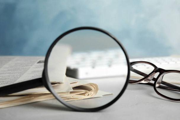 Looking through magnifying glass at newspapers, closeup. Job search concept - Foto, Imagem