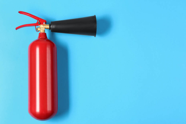 Fire extinguisher on light blue background, top view. Space for text - Foto, Imagen