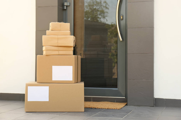 Cardboard boxes near door. Parcel delivery service - Foto, Imagen