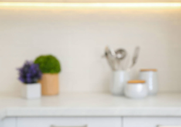 Blurred view of modern kitchen with utensils and houseplants - Valokuva, kuva