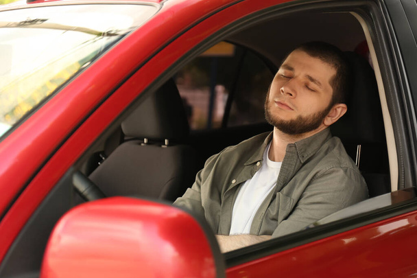Tired man sleeping in his modern car - Photo, image