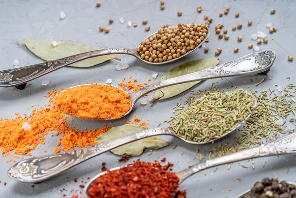 various spices in metal silver spoons with large crystals salt - 写真・画像