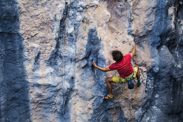 Een sterke man beklimt een rots, Sterke rugspieren, Rotsklimmen in Turkije, Training uithoudingsvermogen en kracht, man in extreme sport, Rotsklimmer is training in de natuur. - Foto, afbeelding
