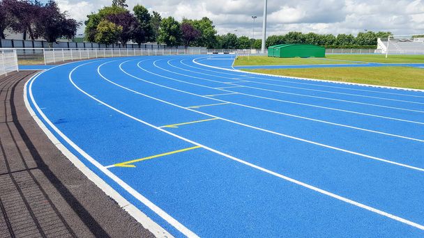 Atletismo en pista azul en un estadio deportivo
 - Foto, Imagen