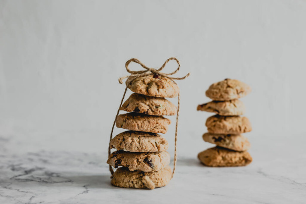 Two stacks of oatmeal cranberry cookies tied up with a packthread - Fotografie, Obrázek