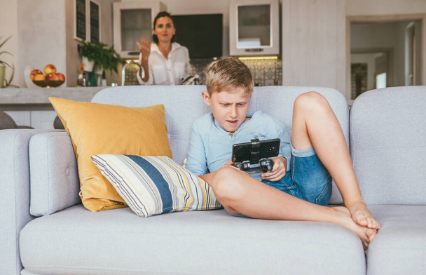 Boy plays with electronic device but his mother not happy with this - Foto, Bild