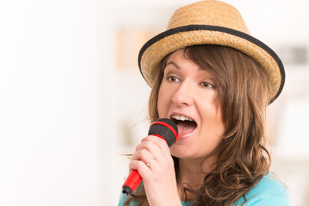 γυναίκα τραγούδι με ένα μικρόφωνο - Φωτογραφία, εικόνα