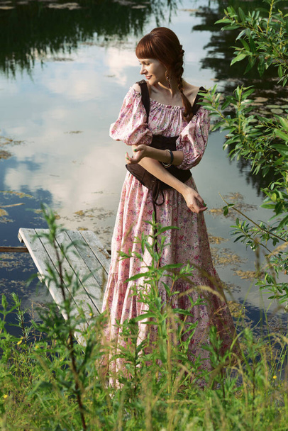 Красива дівчина в довгій сукні в сільській місцевості
 - Фото, зображення