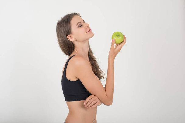 Beauty woman holding green apple while isolated on white - Foto, afbeelding