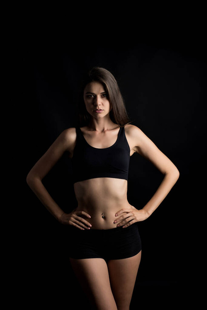 Hermosa mujer con cuerpo sano sobre fondo negro
 - Foto, Imagen