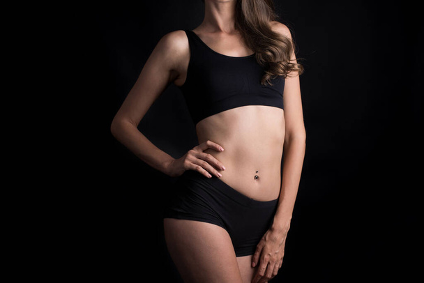 Schöne Frau mit gesundem Körper auf schwarzem Hintergrund - Foto, Bild