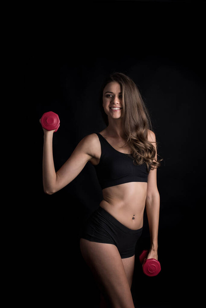 Retrato de jovem bela mulher fazendo exercícios físicos com halteres
 - Foto, Imagem