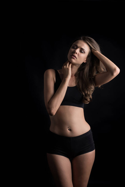 Piękna kobieta ze zdrowym ciałem na czarnym tle - Zdjęcie, obraz