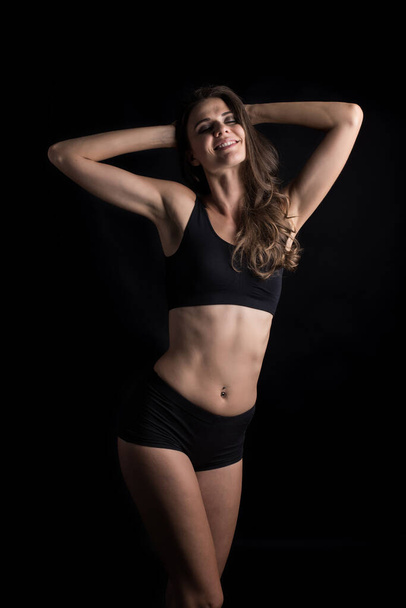 Beautiful woman with healthy body on black background - Foto, Imagen